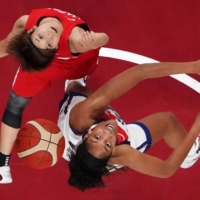 USA\'s A\'ja Wilson (R) and Japan\'s Rui Machida jump for the rebound in the women\'s final basketball match. | AFP-JIJI