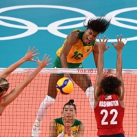 Brazil\'s Fernanda Rodrigues (center) spikes the ball during the women\'s gold medal volleyball match between Brazil and USA. | AFP-JIJI