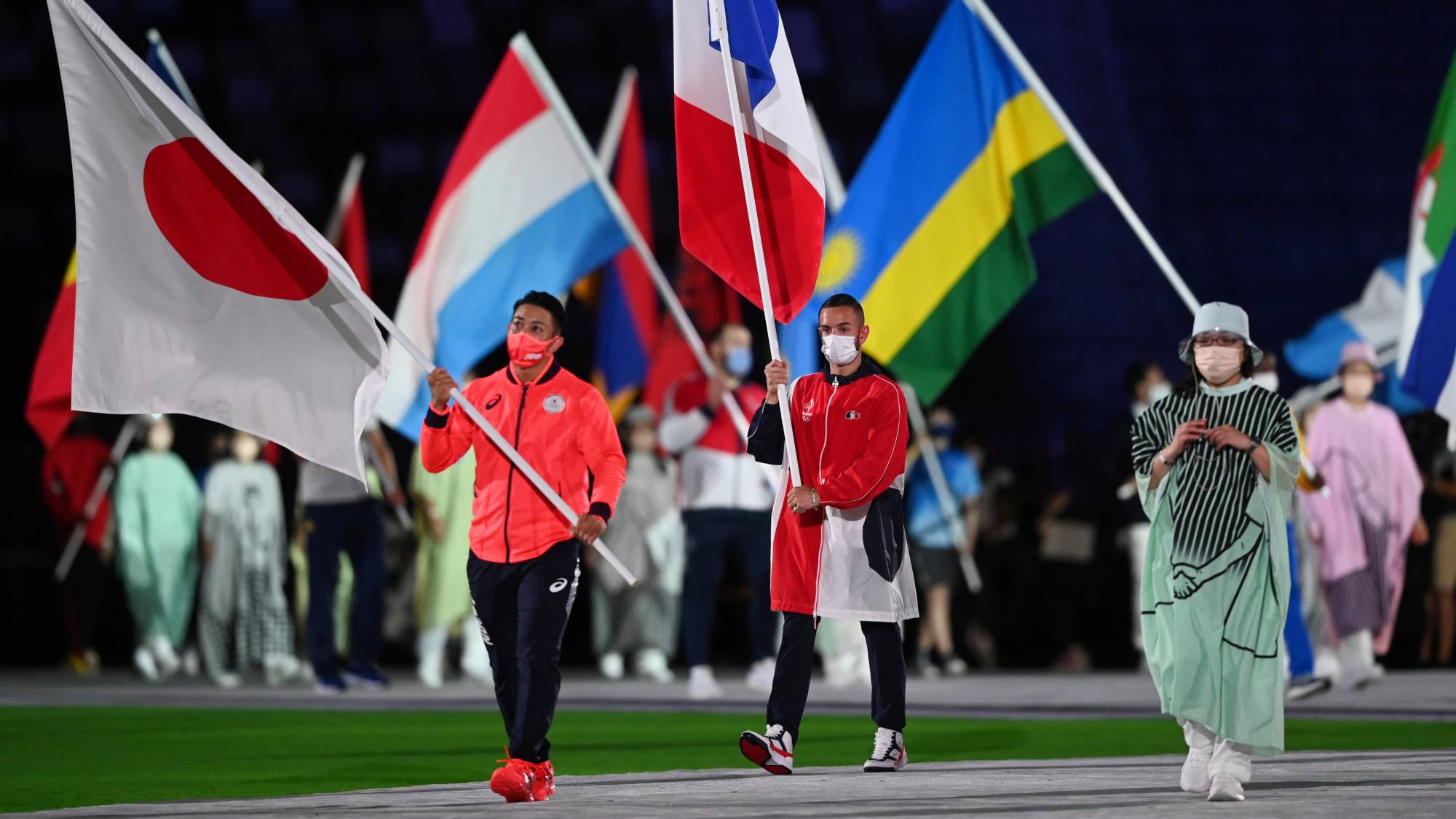 Japan's flag bearer Ryo Kiyuna, gold medalist in karate kata, leads the procession during the closing ceremony of the Olympics. | REUTERS