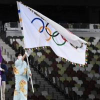 Tokyo\'s governor Yuriko Koike hold the Olympic flag during the closing ceremony of the Tokyo 2020 Olympic Games | AFP-JIJI