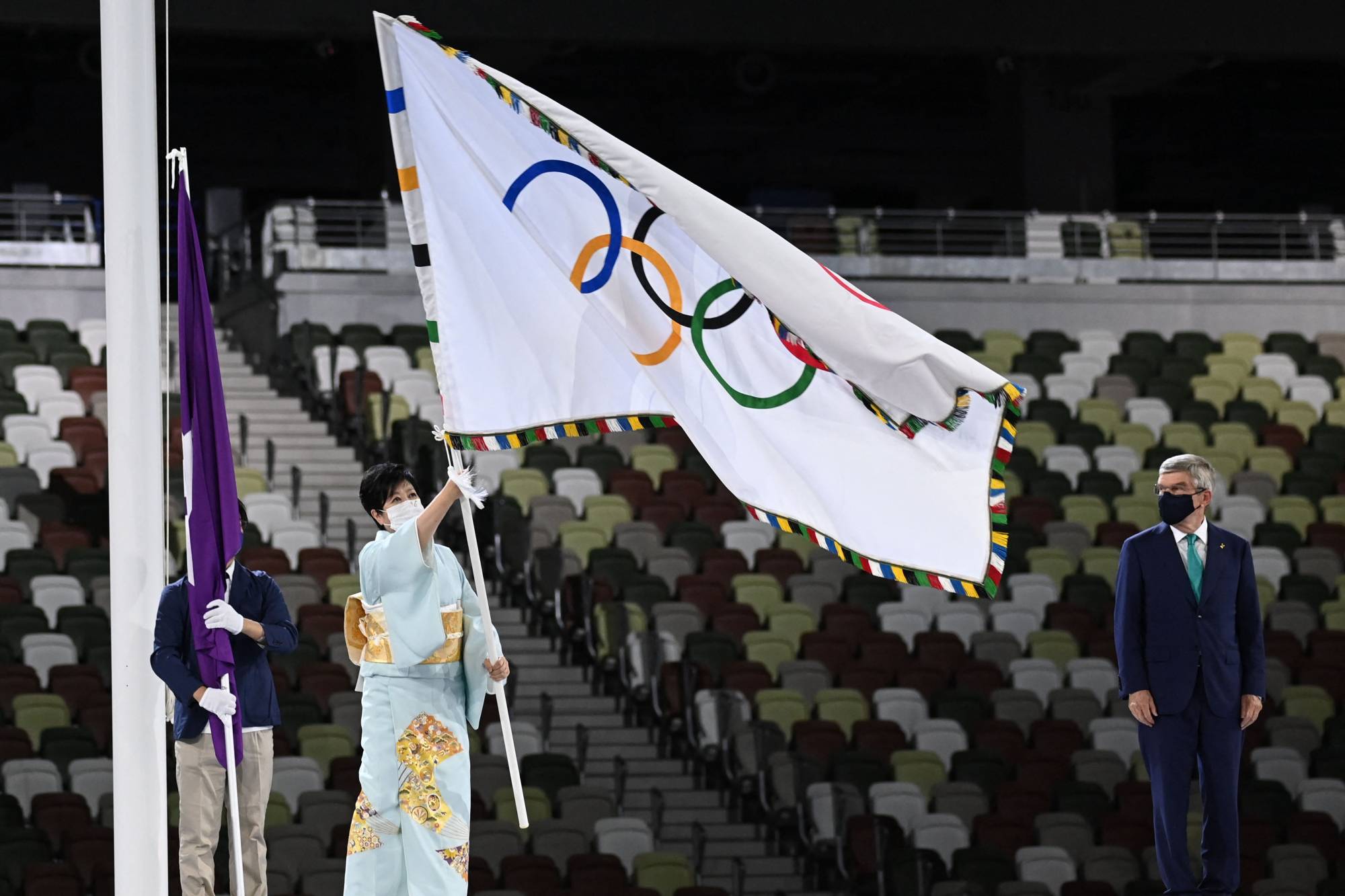 Tokyo's governor Yuriko Koike hold the Olympic flag during the closing ceremony of the Tokyo 2020 Olympic Games | AFP-JIJI