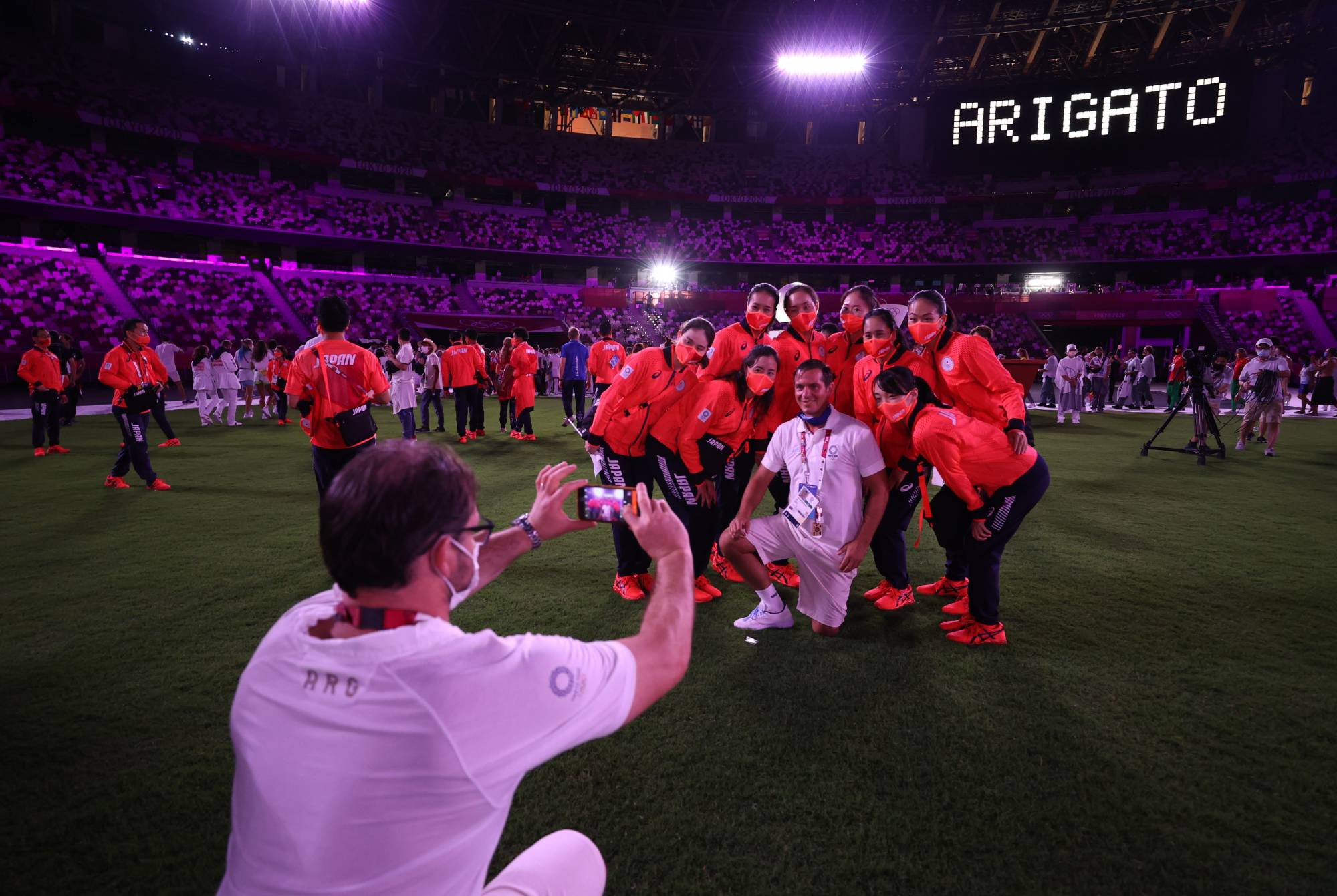 Japanese athletes pose as a thank you message is displayed inside the stadium during the closing ceremony | POOL VIA REUTERS