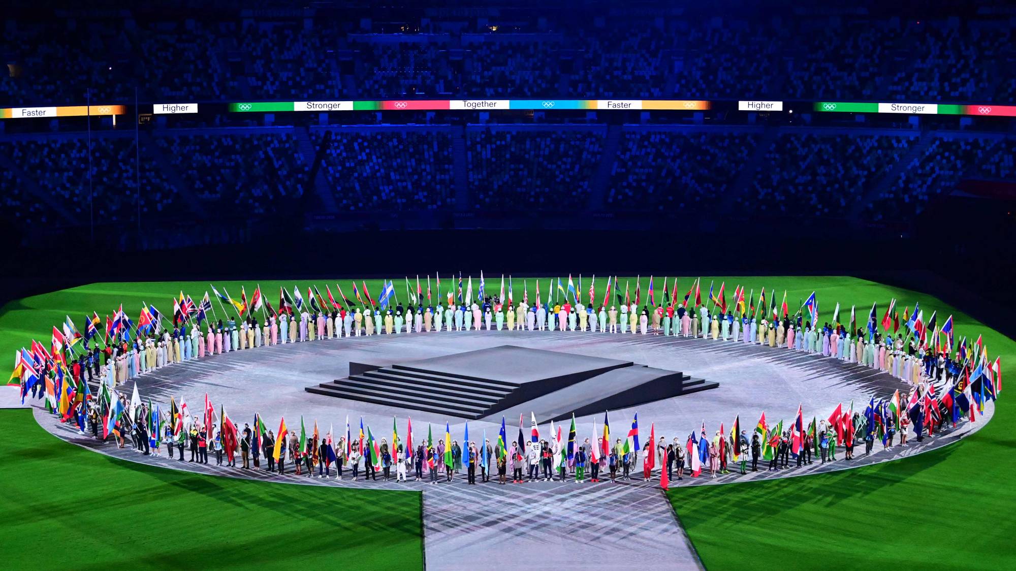 Athlete delegates carry their national flags during the closing ceremony of the Tokyo 2020 Olympic Games. | AFP-JIJI