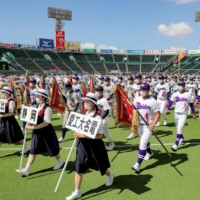 Players march during the opening ceremony of this summer\'s National High School Baseball Championship at Koshien Stadium in Nishinomiya, Hyogo Prefecture, on Tuesday. | POOL / VIA KYODO