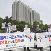 Protesters rally in front of the Seoul District Court in June after the court dismissed a wartime labor compensation lawsuit. | KYODO
