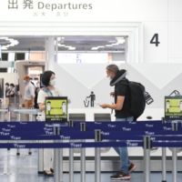 A traveler heads to the departure gates at Tokyo\'s Haneda Airport on Monday. | BLOOMBERG