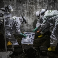 Volunteers bury the body of a baby, whose mother tested positive for COVID-19, hours after it was born, in Yogyakarta, Indonesia, on Friday. | ULET IFANSASTI/THE NEW YORK TIMES