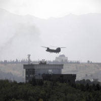 A U.S. helicopter flies above the American Embassy in Kabul as the Taliban reached the gates of the Afghan capital on Sunday. | AP / VIA KYODO 