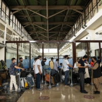 Afghans and travelers pass through checkpoints at Hamid Karzai International Airport in Kabul, ahead of the Taliban:s arrival on Sunday. | JIM HUYLEBROEK/THE NEW YORK TIMES