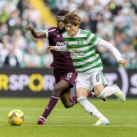 Kyogo Furuhashi (right) of Celtic vies for the ball during the second half of a game against Hearts in Glasgow on Sunday. | KYODO