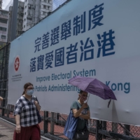 A government billboard hangs in Hong Kong, after Beijing announced in May that only patriots were allowed to run the city. When Hong Kong’s pro-democracy politicians won a resounding victory in local council elections in 2019, they inspired hopes of democratic change. Now, fears of arrest have driven most of them to quit, laying bare that dream’s dramatic collapse. | LAM YIK FEI/THE NEW YORK TIMES
