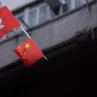The flags of Hong Kong and China hang above a street in the city on Sunday.  | AFP-JIJI