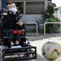 Mari Nagaoka, a power wheelchair soccer player in Yokohama, practices alone in the summer heat at her local park, as the pandemic has forced her team to stop training together at a gymnasium. | TOMOHIRO OSAKI
