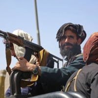 Taliban fighters stand guard along the roadside in Kabul on Monday after their stunningly swift offensive that toppled Afghanistan\'s government after nearly a 20-year war.   | AFP-JIJI