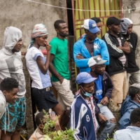 People watch the clearing of a building that collapsed during the earthquake in Brefet, a neighborhood in Les Cayes, Haiti. | AFP-JIJI