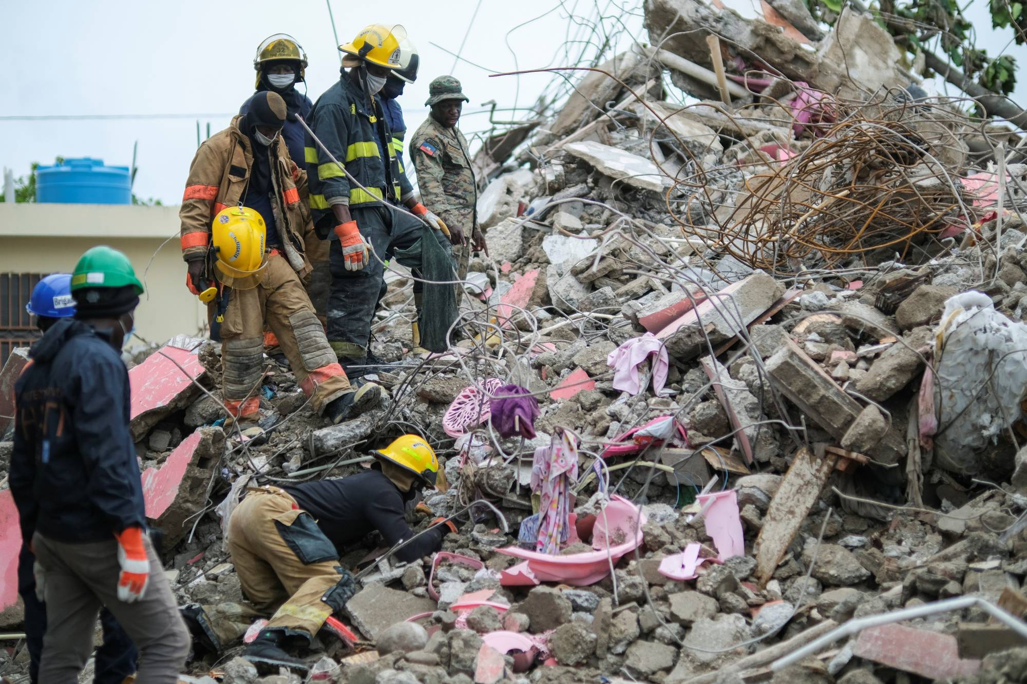 Haitian firefighters search for survivors under the rubble of a destroyed building after Saturday's 7.2 magnitude quake in Les Cayes, Haiti. | Reuters