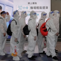 Passengers line up to board an international flight in Hong Kong in July.  | REUTERS