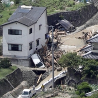 Cars have been swept away by a mudslide, caused by heavy rain, in the city of Hiroshima on Sunday. | KYODO