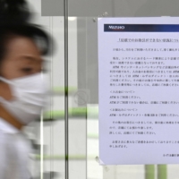 A sign notifying customers about a system failure at a Mizuho Bank branch in Tokyo\'s Minato Ward on Friday | KYODO