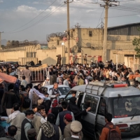 People gather near the airport in Kabul on Saturday.  | JIM HUYLEBROEK / THE NEW YORK TIMES