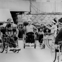 Katsumi Suzaki (center) takes part in a men\'s wheelchair basketball event during the Tokyo Paralympics in November 1964. | COURTESY OF JAPAN SUN INDUSTRIES / VIA KYODO