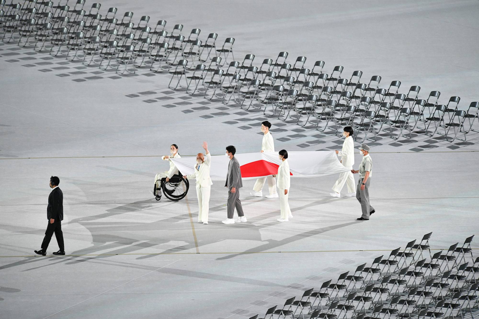 Athletes carry the Japanese national flag at the beginning of the opening ceremony. | DAN ORLOWITZ 