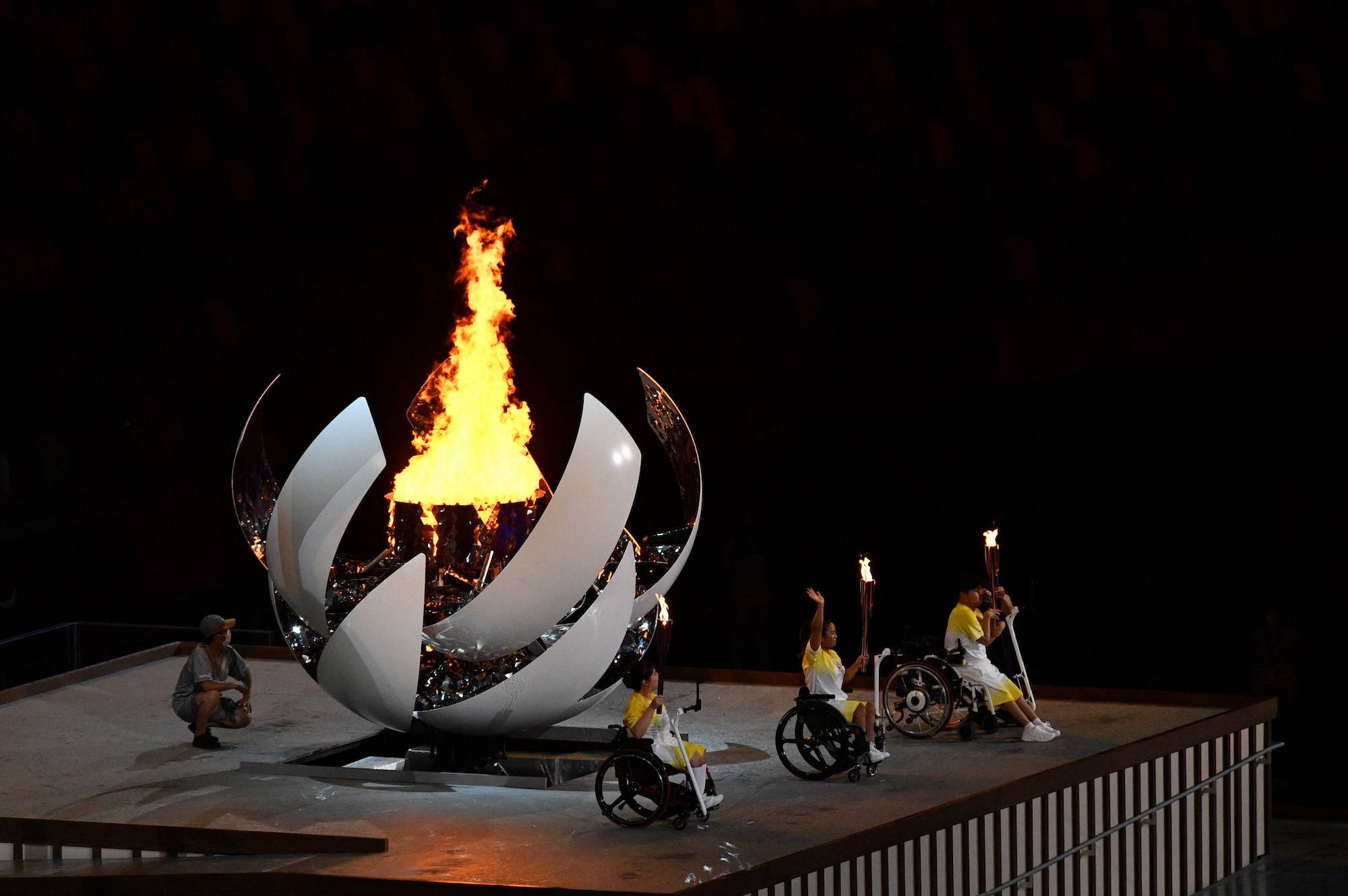 Japanese Paralympians pose in front of the lit cauldron | DAN ORLOWITZ 