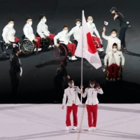 Japan\'s Koyo Iwabuchi and Mami Tani carry the national flag | REUTERS