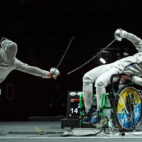 China\'s Li Hao (left) competes with Ukraine\'s Artem Manko during the men\'s sabre individual category A gold medal wheelchair fencing bout | AFP-JIJI
