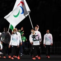 Alia Issa and Abbas Karimi of the Refugee Paralympic Team lead their contingent during the athletes parade at the opening ceremony of the Paralympics on Tuesday.  | REUTERS