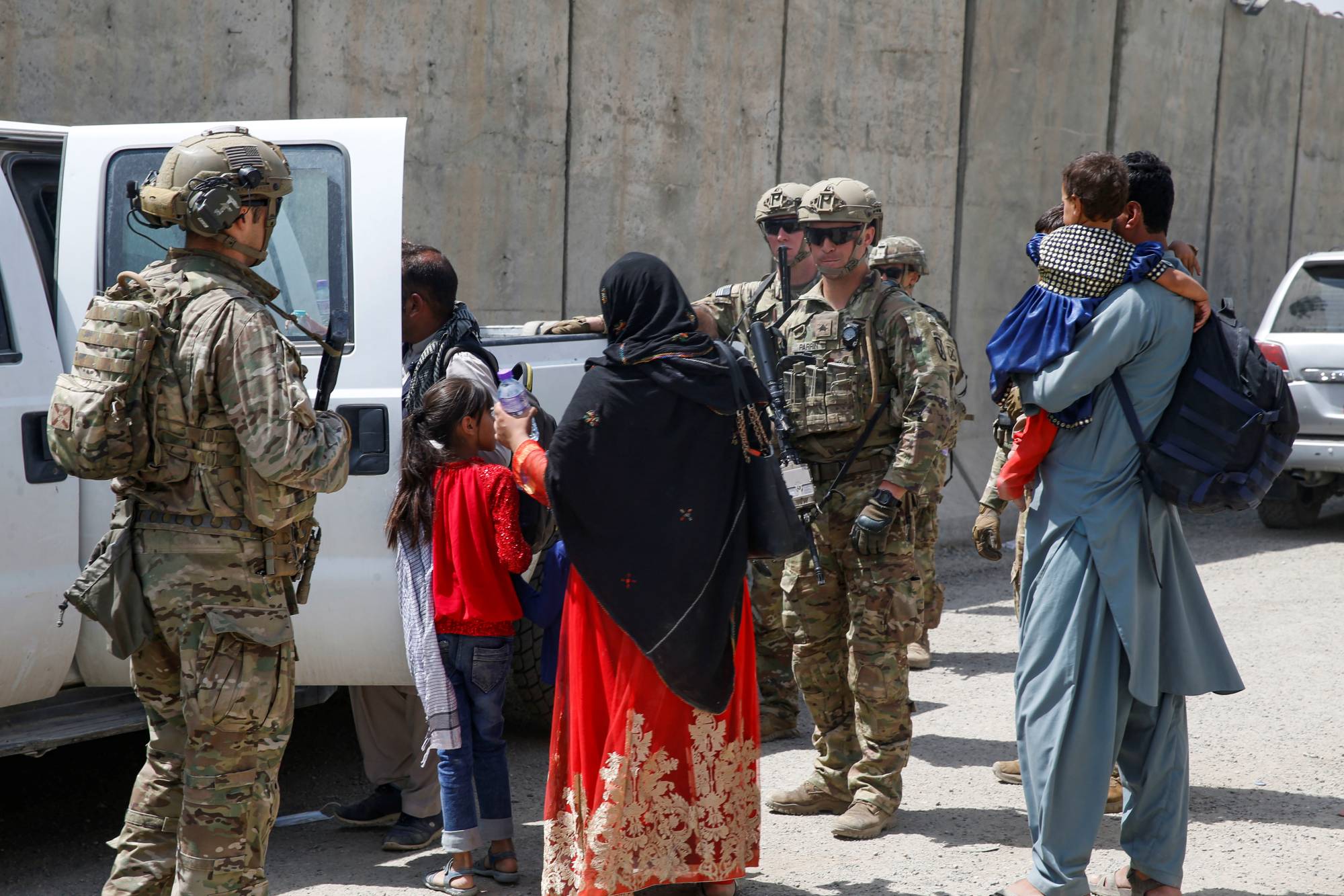 U.S. soldiers assist Afghan civilians during the evacuation effort at the international airport in Kabul on Aug. 20. | U.S. MARINE CORPS / VIA REUTERS    