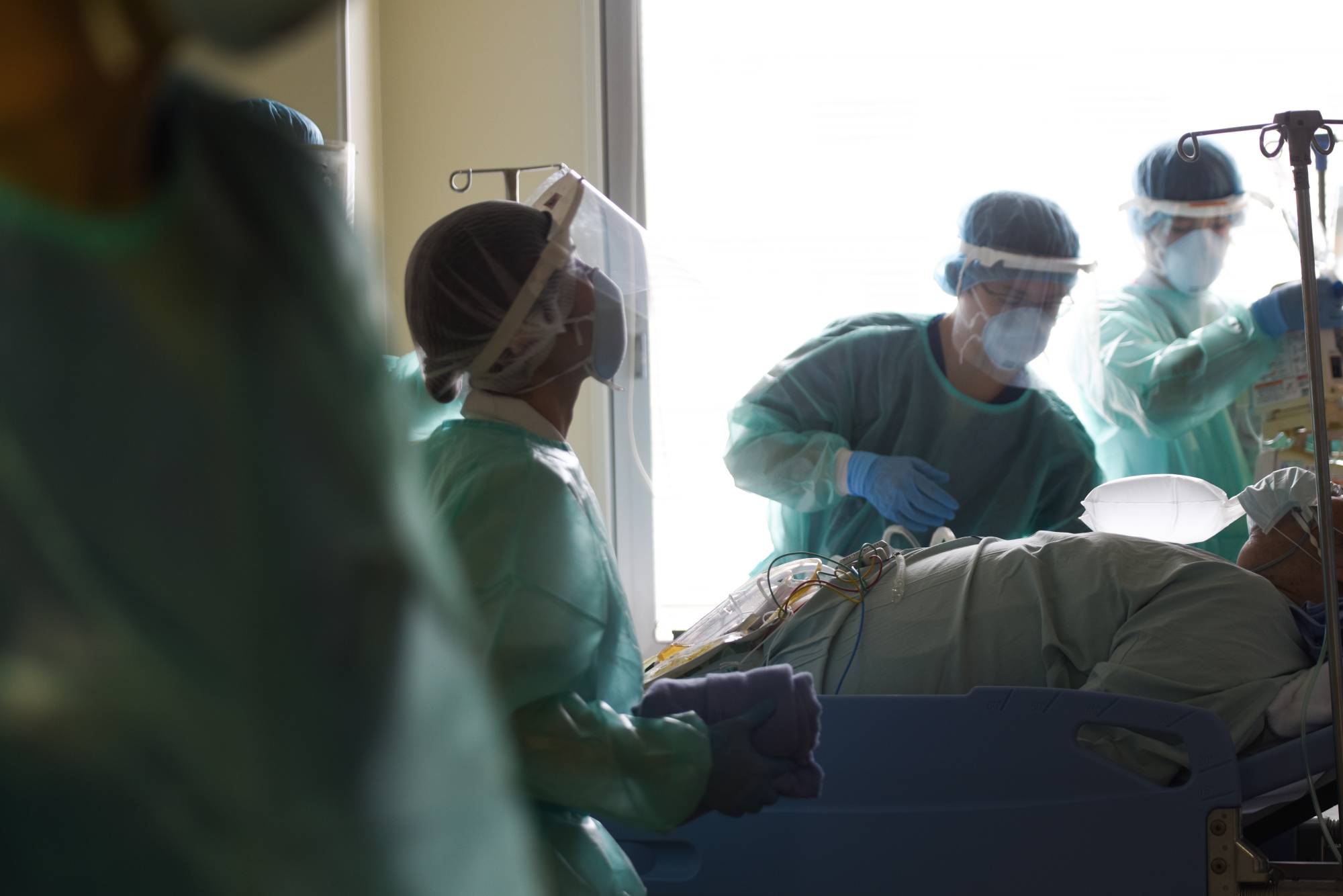 Health care workers treat a patient in a COVID-19 ward at Chiba University Hospital in Chiba Prefecture on Wednesday. | BLOOMBERG