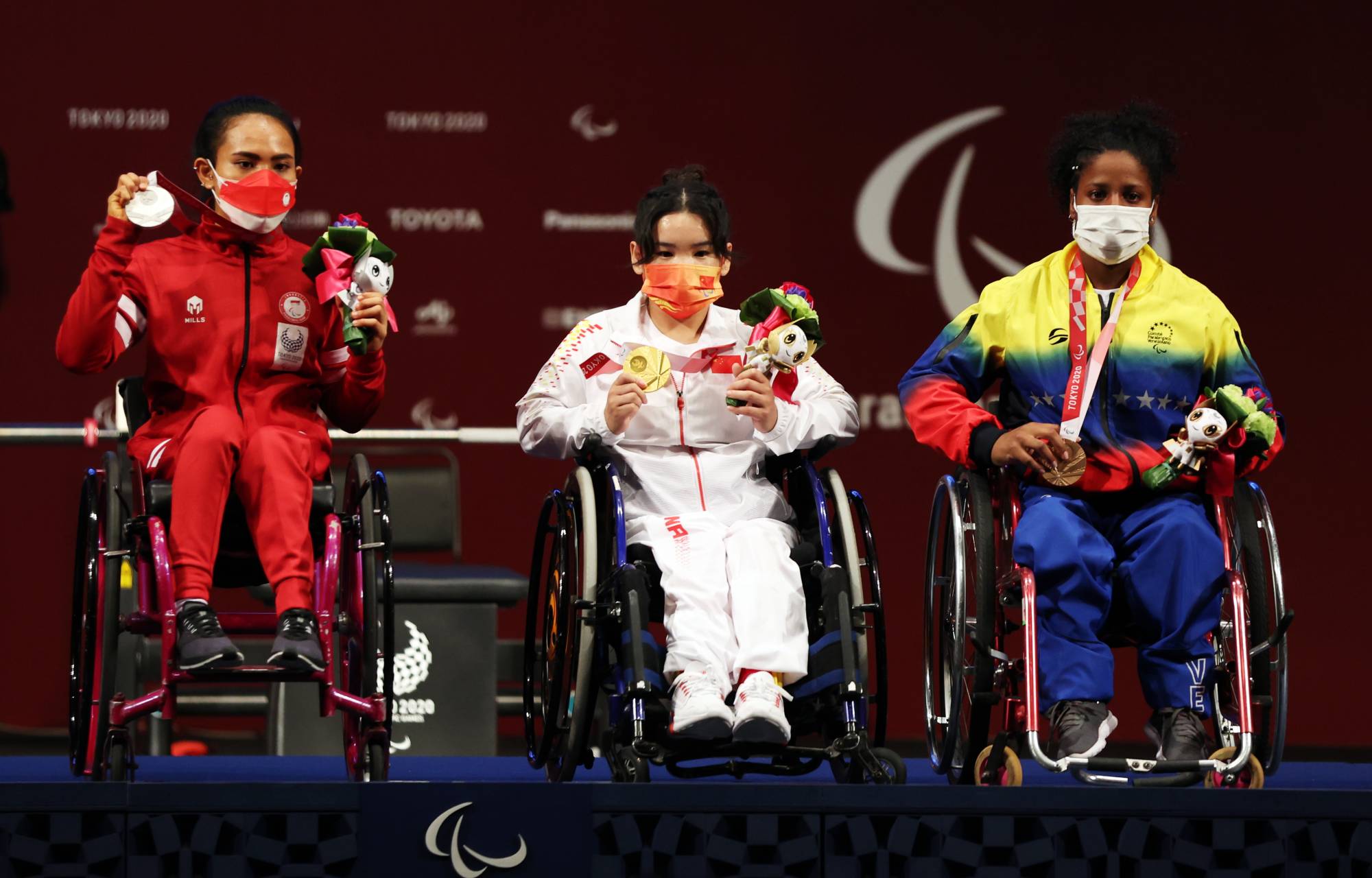 Gold medalist Lingling Guo of China, silver medalist Ni Nengah Widiasih of Indonesia and bronze medalist Clara Sarahy Fuentes Monasterio of Venezuela celebrate after the women's under-41 kg final at Tokyo International Forum.  | Reuters