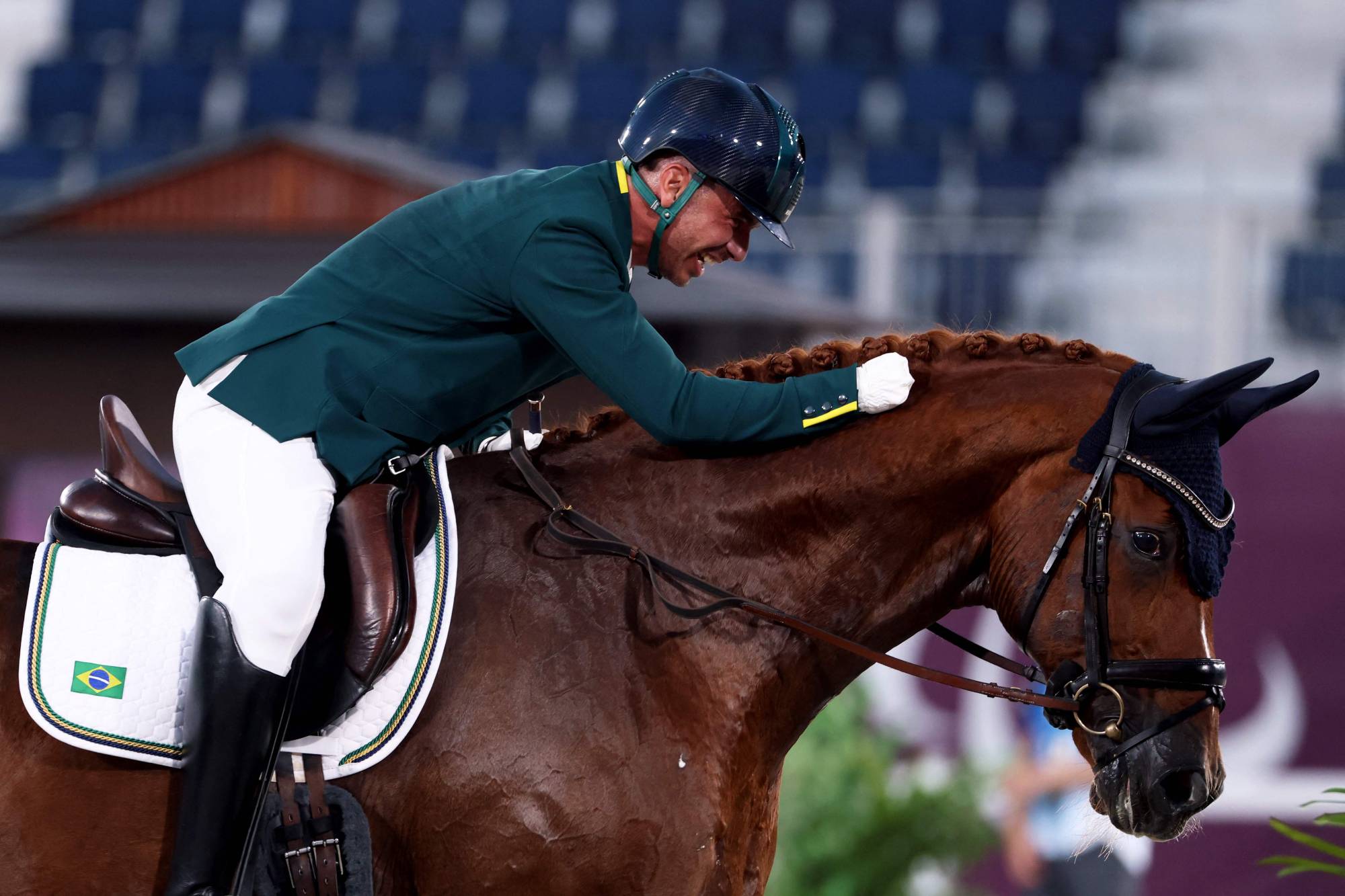 Brazil's Rodolpho Riskalla riding hugs his horse, Don Henrico, after competing in the equestrian dressage individual test grade IV | AFP-JIJI