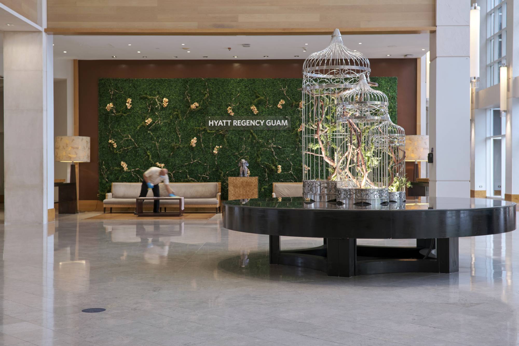 A worker cleans furniture in the lobby of the Hyatt Regency Guam in Tmon, Guam, on Aug. 21. The hotel has let go about 100 full- and part-time employees. | Anthony Henri Oftana / The New York Times