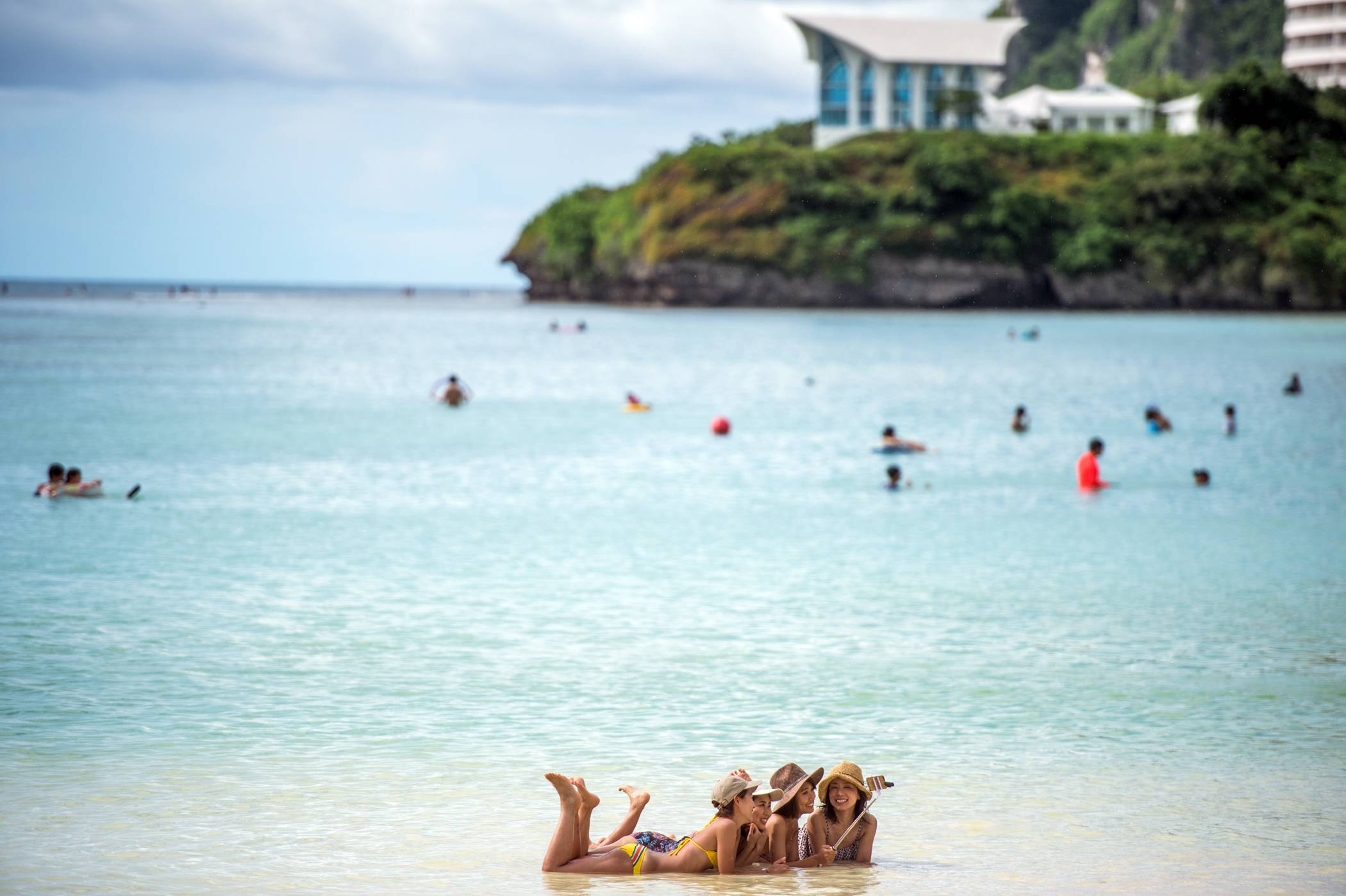Tourists on the beach at Tumon Bay, Guam, in August 2017. | Nancy Borowick / The New York Times