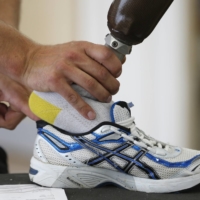 A technician fits a prosthetic foot into a trainer in an Ottobock workshop at the London athletes\' village in 2012.  | REUTERS
