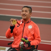 Tomoki Sato celebrates with his gold medal after the men\'s T52 400-meter final on Friday.  | DAN ORLOWITZ
