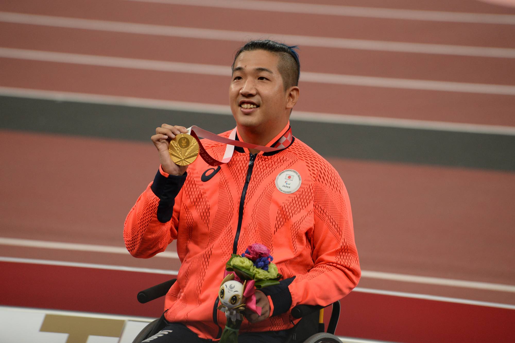 Tomoki Sato celebrates with his gold medal after the men's T52 400-meter final on Friday. | DAN ORLOWITZ 