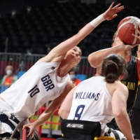 Katharina Lang of Germany in action against Amy Conroy and Laurie Williams of Britain during a preliminary round of wheelchair basketball.  | REUTERS