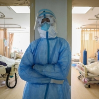 A medical staff member rests at the isolation ward of the Wuhan Red Cross Hospital in Wuhan, China, in February last year.  | AFP-JIJI