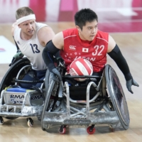 Japan\'s Katsuya Hashimoto fights off Britain\'s Aaron Phipps during the fourth period of the wheelchair rugby semifinals on Saturday.  | KYODO 