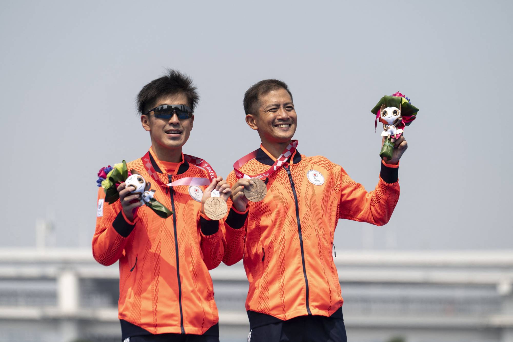 Bronze medalists Satoru Yoneoka and Kohei Tsubaki pose with their medals after competing in the men's PTVI Paralympic triathlon. | AFP-JIJI