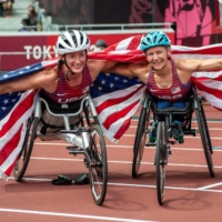 Bronze medalist Tatyana McFadden (left) and gold medalist Susannah Scaroni celebrate after the women\'s T54 5000 meters. | AFP-JIJI