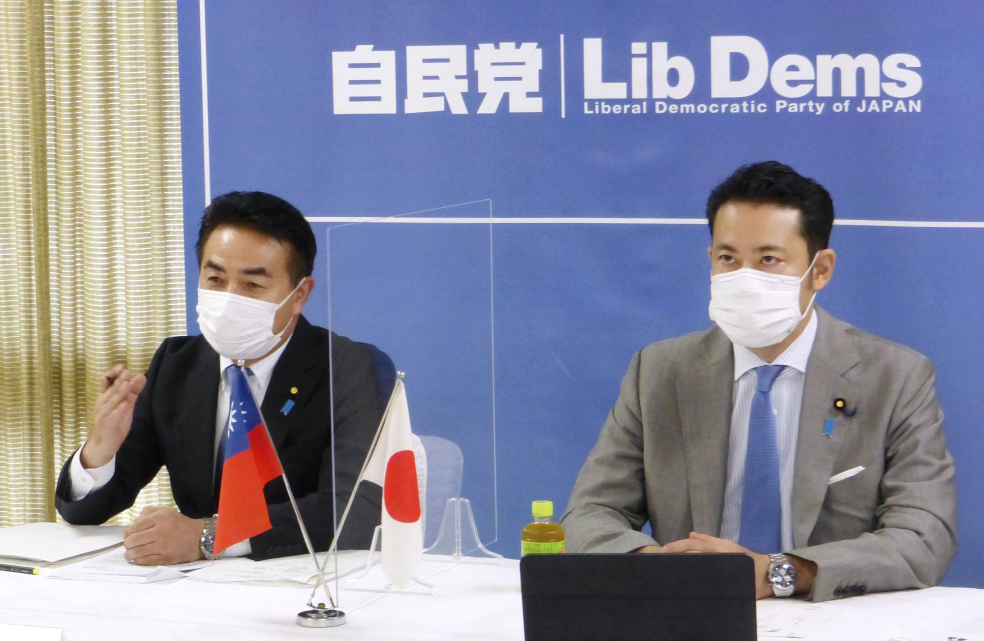 Liberal Democratic Party Foreign Affairs Division chief Masahisa Sato and National Defense Division head Taku Otsuka attend an online meeting with lawmakers from Taiwan's ruling party at LDP headquarters in Tokyo on Friday. | KYODO