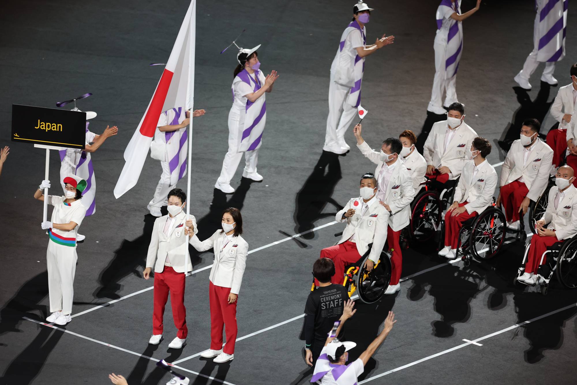 Koyo Iwabuchi (left) and Mami Tani carry the flag during the opening ceremony of the Tokyo Paralympics. | Reuters