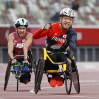 Japan\'s Tomoki Sato crosses the finish line ahead of USA\'s Raymond Martin in the men’s wheelchair T52 1,500 meters. | REUTERS