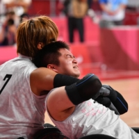 Wheelchair rugby athlete Daisuke Ikezaki consoles teammate Katsuya Hashimoto after their last Paralympic match, for the bronze medal.   | DAN ORLOWITZ
