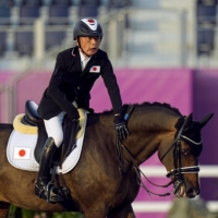 Mitsuhide Miyaji strokes his horse after competing in the equestrian Dressage Individual Test Grade II event at the Tokyo Paralympics on Thursday. | KYODO