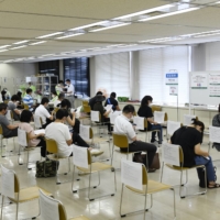 Residents wait in an observation area after receiving the Moderna Inc. COVID-19 vaccine at a mass vaccination site in Saitama on Aug. 23. | BLOOMBERG